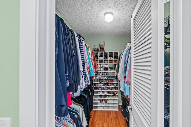 bedroom featuring a ceiling fan, light wood-style flooring, and a textured ceiling