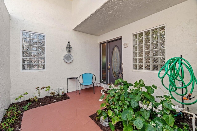 doorway to property featuring a patio and stucco siding