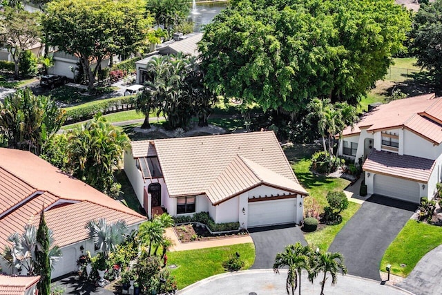 rear view of property with a sunroom, central AC, a tile roof, stucco siding, and a yard