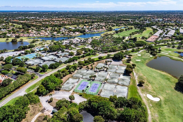 drone / aerial view featuring a residential view, golf course view, and a water view