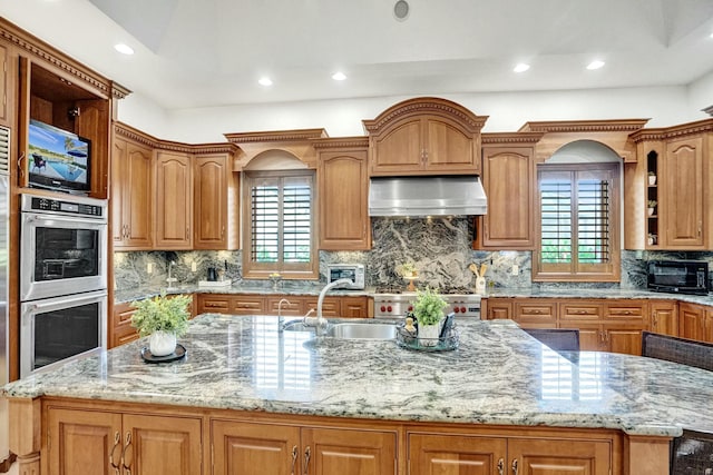 kitchen with open shelves, appliances with stainless steel finishes, a kitchen island with sink, and ventilation hood