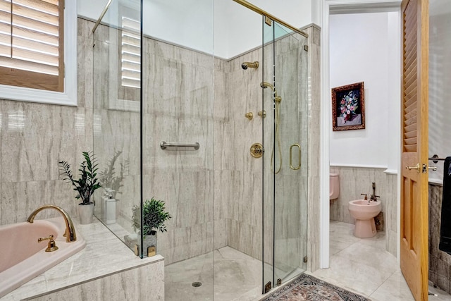 bathroom featuring tile walls, a bath, a bidet, and a stall shower