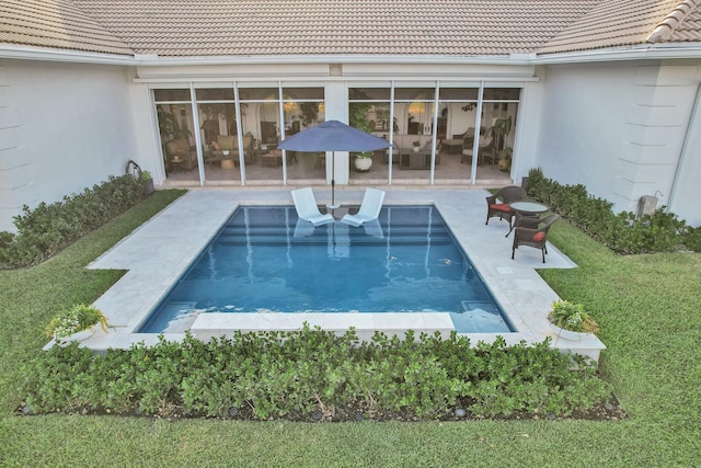 pool featuring a patio area and a yard