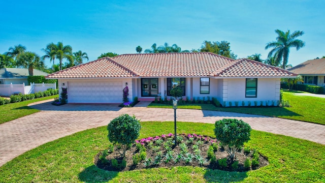 4730 S Lake Dr, Boynton Beach, FL 33436 - view of front of property with stucco siding, a front lawn, a tiled roof, decorative driveway, and a garage
