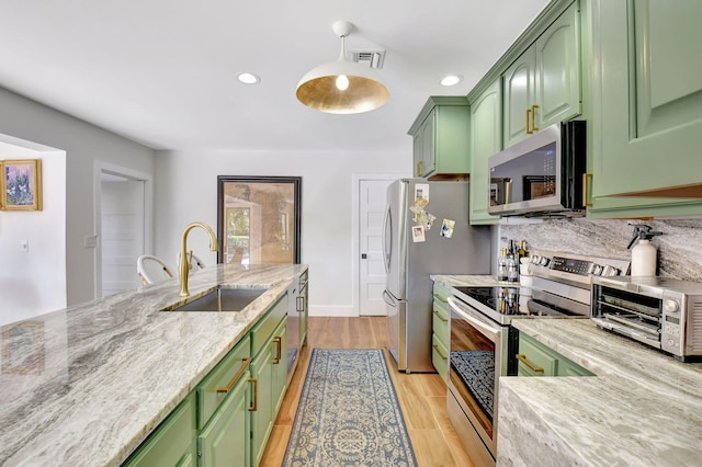 4730 S Lake Dr, Boynton Beach, FL 33436 - kitchen with green cabinets, visible vents, stainless steel appliances, a sink, and backsplash