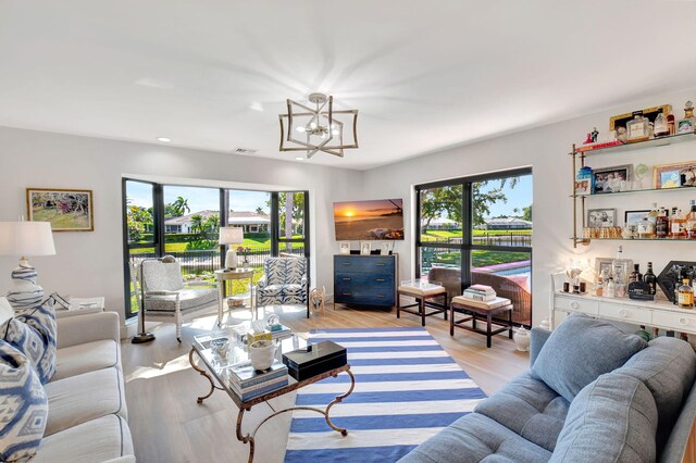4730 S Lake Dr, Boynton Beach, FL 33436 - living area with a bar, a notable chandelier, plenty of natural light, and light wood-style flooring