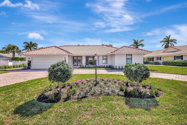 4730 S Lake Dr, Boynton Beach, FL 33436 - view of front of home with an attached garage, a tile roof, a front yard, and decorative driveway