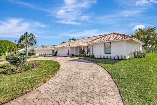 4730 S Lake Dr, Boynton Beach, FL 33436 - view of front of home with decorative driveway, an attached garage, a tile roof, a front lawn, and stucco siding