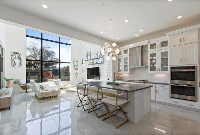 8451 Grand Prix Ln, Boynton Beach, FL 33472 - kitchen with a kitchen bar, tasteful backsplash, a sink, appliances with stainless steel finishes, and wall chimney exhaust hood