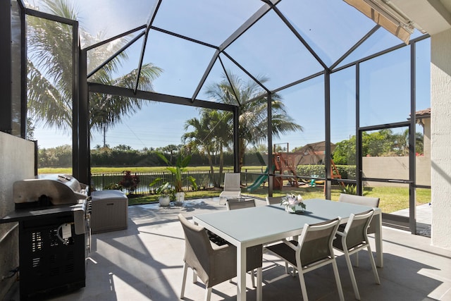 8451 Grand Prix Ln, Boynton Beach, FL 33472 - view of patio / terrace with a fenced backyard, a playground, outdoor dining area, and a lanai