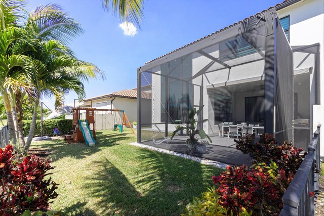8451 Grand Prix Ln, Boynton Beach, FL 33472 - view of yard featuring fence, a lanai, a patio area, and a playground