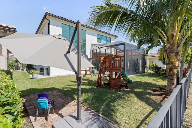 8451 Grand Prix Ln, Boynton Beach, FL 33472 - back of house with a fenced backyard, a lawn, stucco siding, and a playground