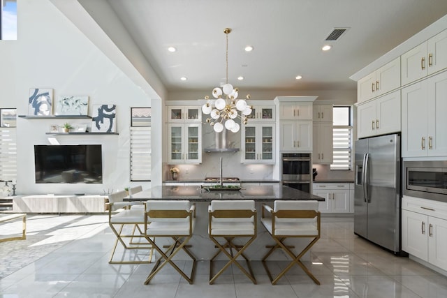8451 Grand Prix Ln, Boynton Beach, FL 33472 - kitchen with visible vents, a breakfast bar area, decorative backsplash, and appliances with stainless steel finishes