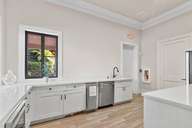 8451 Grand Prix Ln, Boynton Beach, FL 33472 - kitchen featuring crown molding, white cabinetry, a sink, light wood-style floors, and stainless steel dishwasher