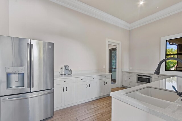 8451 Grand Prix Ln, Boynton Beach, FL 33472 - kitchen featuring white cabinets, crown molding, a sink, light wood-style floors, and stainless steel fridge with ice dispenser