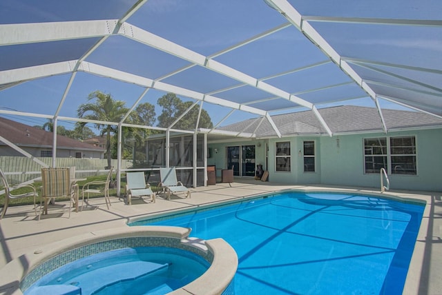 view of pool featuring a patio, fence, a pool with connected hot tub, and a lanai