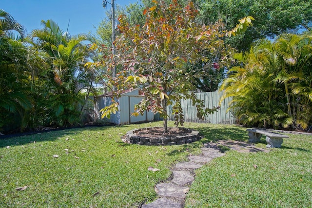 view of yard featuring a storage shed, an outdoor structure, and fence