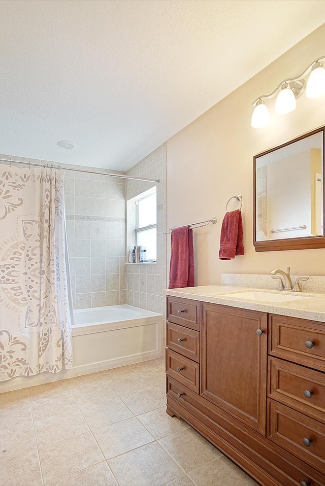 full bath with tile patterned flooring, a textured ceiling, vanity, and shower / tub combo with curtain