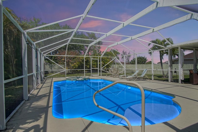 pool at dusk with glass enclosure, a patio, and a fenced backyard