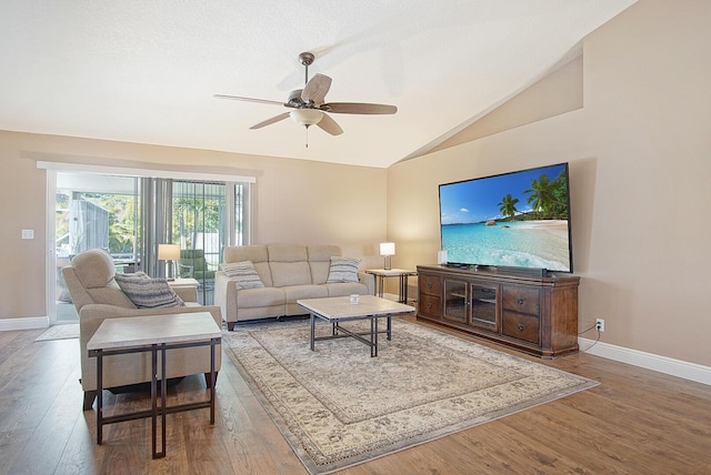 living area with ceiling fan, baseboards, lofted ceiling, and wood finished floors