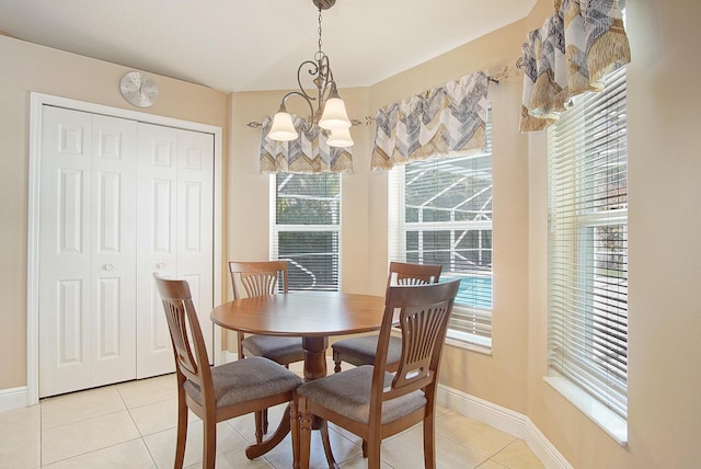 dining space featuring light tile patterned floors, baseboards, and a notable chandelier