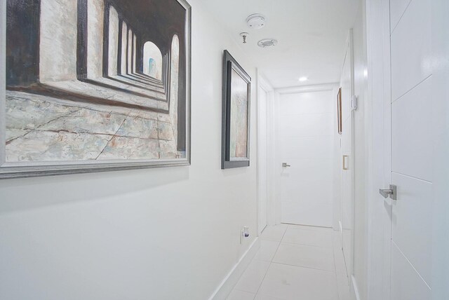 hall with baseboards and tile patterned flooring