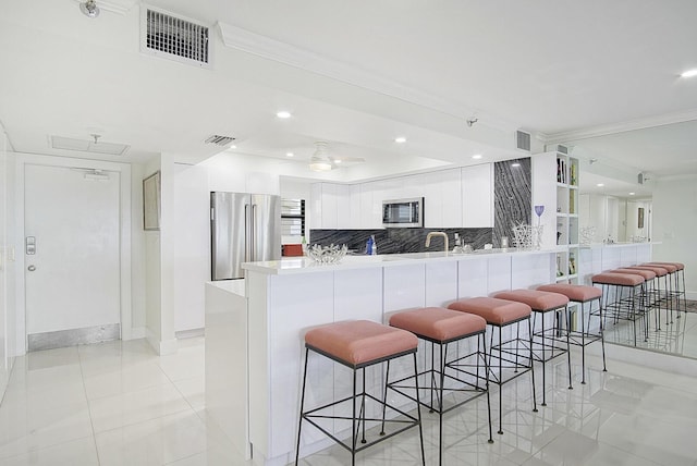 kitchen featuring white cabinets, modern cabinets, visible vents, and stainless steel appliances