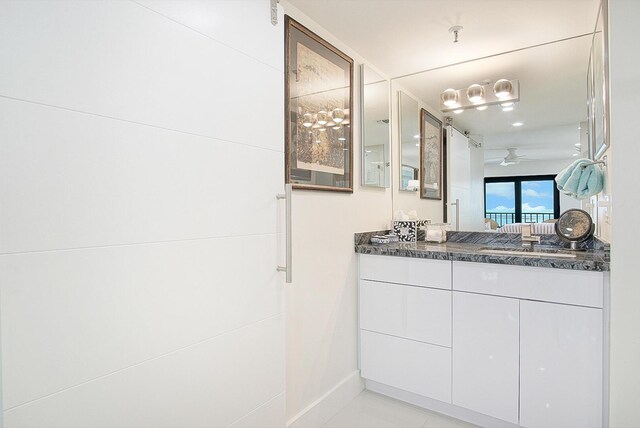 bathroom with baseboards, ceiling fan, and vanity