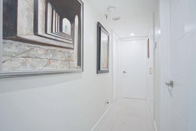 hallway featuring tile patterned flooring and baseboards
