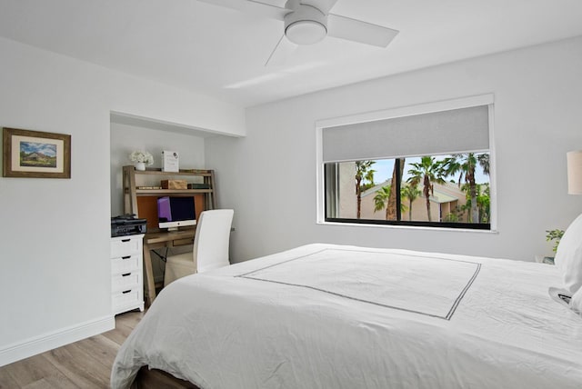 bedroom featuring baseboards, wood finished floors, and ceiling fan