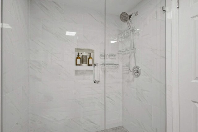 bathroom featuring a marble finish shower