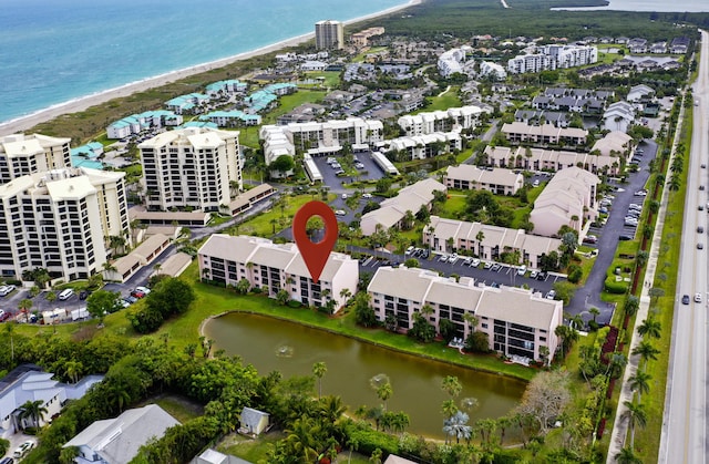 birds eye view of property featuring a beach view and a water view