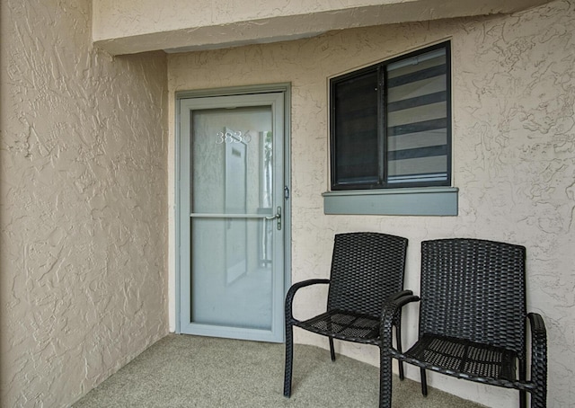 view of exterior entry featuring stucco siding