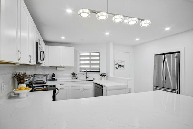 kitchen featuring recessed lighting, a sink, white cabinets, light stone countertops, and appliances with stainless steel finishes