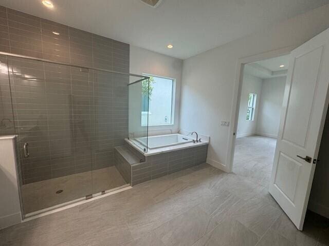 10009 Driftwood Way, Palm Beach Gardens, FL 33412 - bathroom featuring a bath, a shower stall, recessed lighting, and baseboards