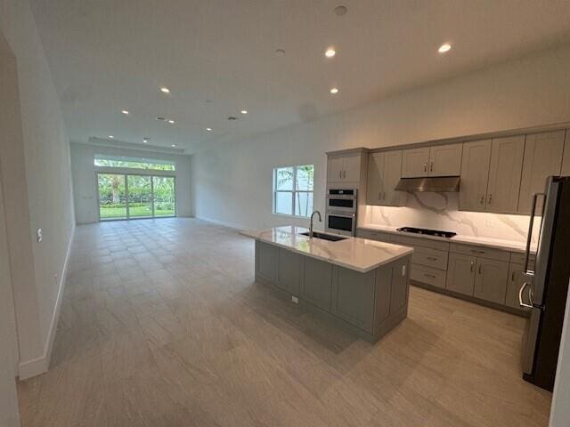 10009 Driftwood Way, Palm Beach Gardens, FL 33412 - kitchen with gray cabinetry, under cabinet range hood, appliances with stainless steel finishes, healthy amount of natural light, and recessed lighting