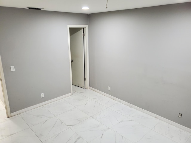 spare room with marble finish floor, baseboards, visible vents, and recessed lighting