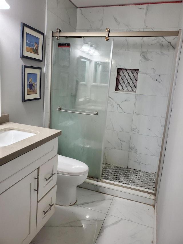 full bathroom with toilet, marble finish floor, vanity, and a stall shower