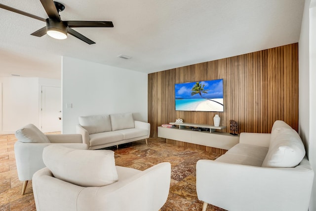 420 SW 128th Ave, Miami, FL 33184 - living area with stone finish flooring, a textured ceiling, wooden walls, and ceiling fan