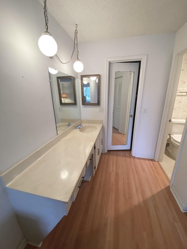 2721 SW 15th St Unit 202, Delray Beach, FL 33445 - bathroom with wood finished floors, a textured ceiling, and vanity