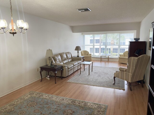 2721 SW 15th St Unit 202, Delray Beach, FL 33445 - living area with wood finished floors, a chandelier, and a textured ceiling