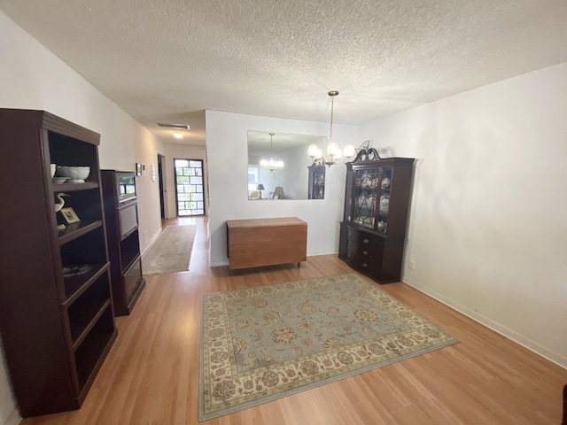 2721 SW 15th St Unit 202, Delray Beach, FL 33445 - dining space with a chandelier, wood finished floors, and a textured ceiling