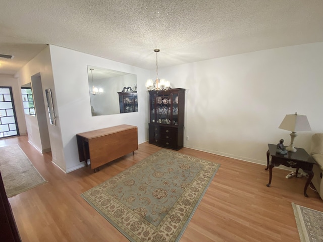 2721 SW 15th St Unit 202, Delray Beach, FL 33445 - dining area with wood finished floors, a chandelier, and a textured ceiling