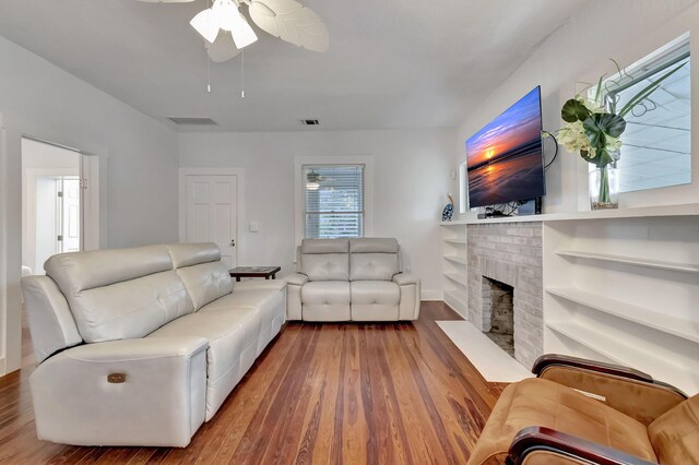 320 SE 4th Ave, Delray Beach, FL 33483 - living room featuring a ceiling fan, visible vents, a fireplace, and wood finished floors
