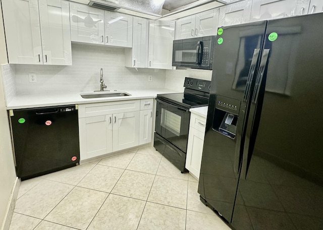 kitchen with a sink, black appliances, white cabinets, and light countertops