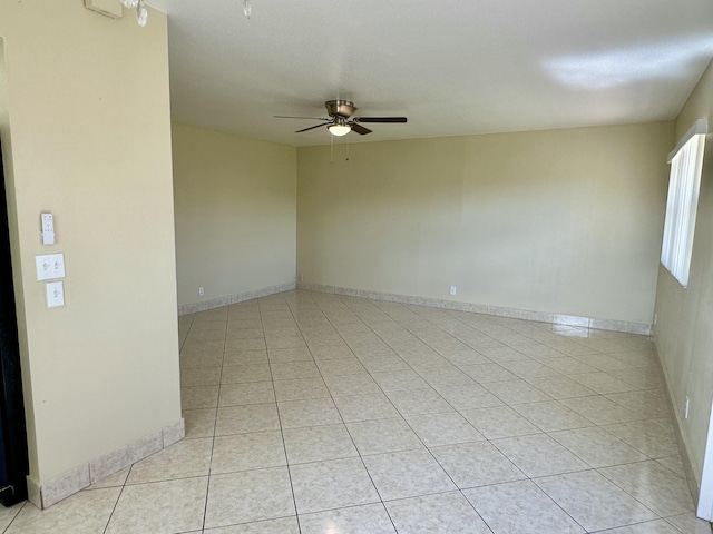 spare room with light tile patterned flooring, baseboards, and a ceiling fan