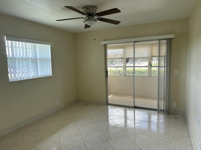 empty room featuring light tile patterned floors, baseboards, and ceiling fan
