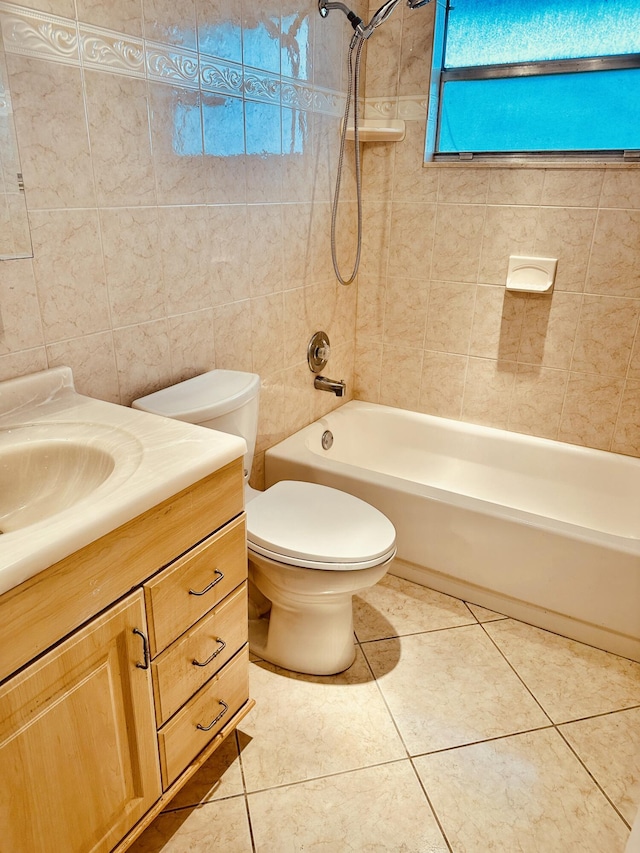 bathroom featuring tile patterned flooring, tile walls, toilet, shower / bath combination, and vanity