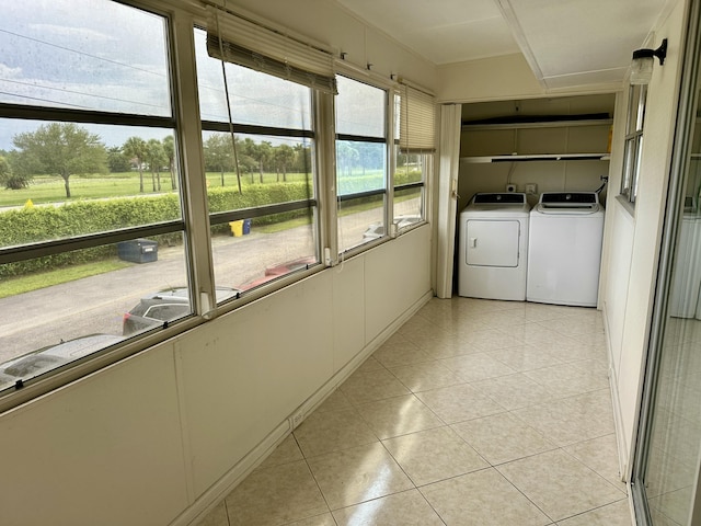 washroom with light tile patterned flooring, washing machine and dryer, and laundry area