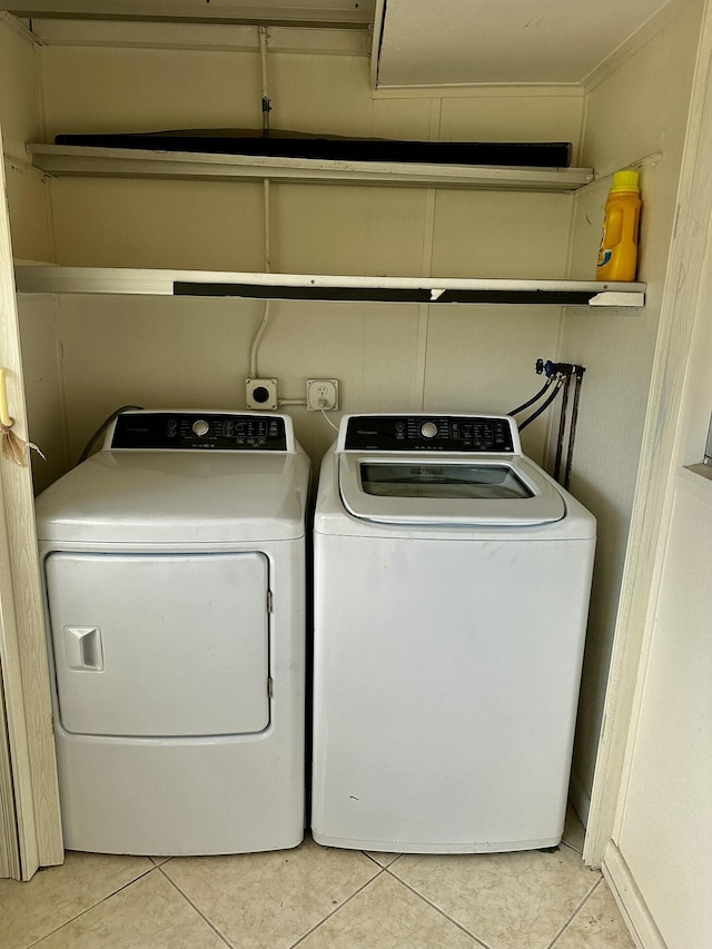 clothes washing area with light tile patterned floors, laundry area, and washing machine and dryer